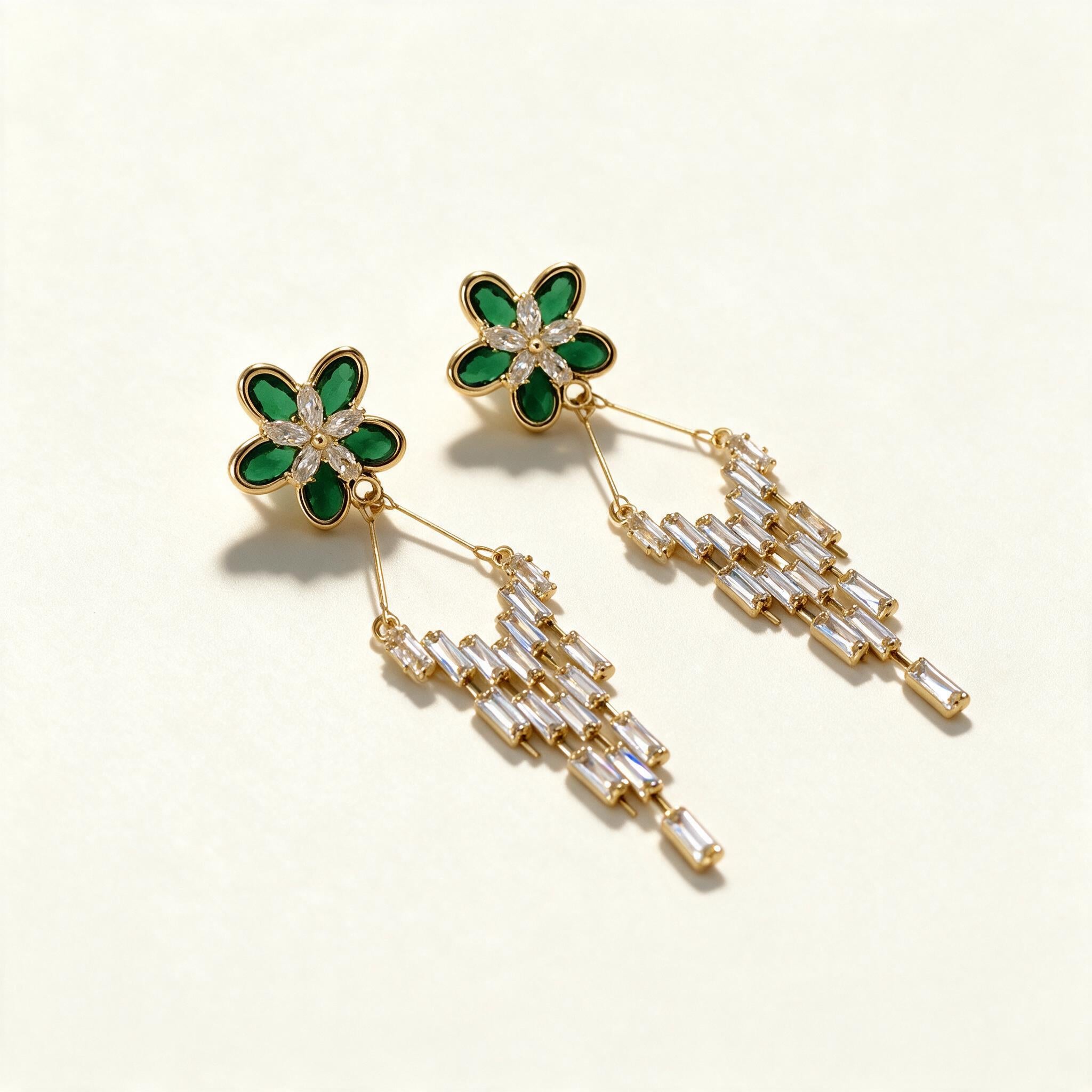 Gold-tone drop earrings with a green stone flower top and a staggered fringe of baguette crystals