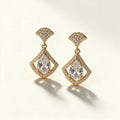 Gold-tone drop earrings with pave fan stud and pear-cut crystal inside a kite shaped halo frame