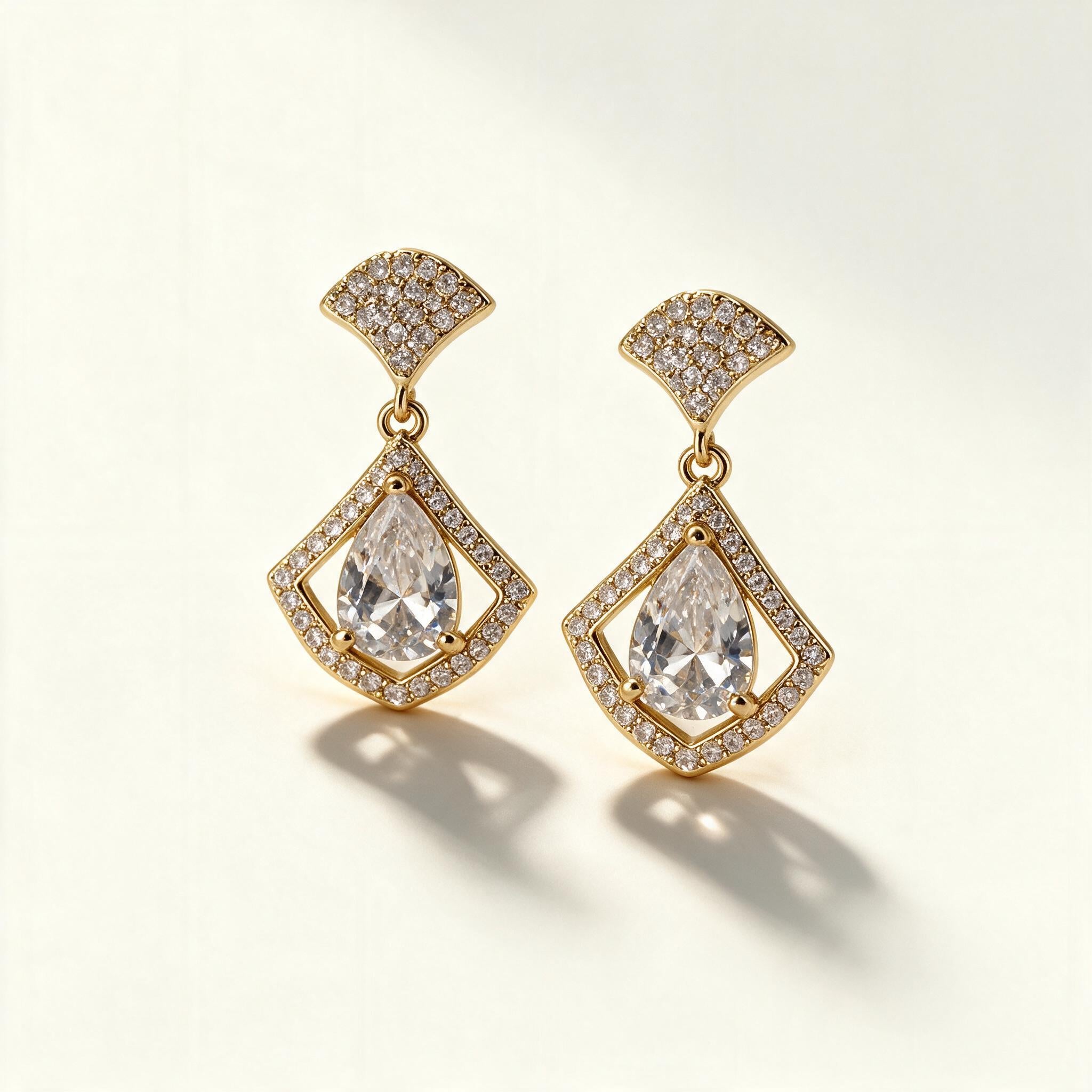 Gold-tone drop earrings with pave fan stud and pear-cut crystal inside a kite shaped halo frame