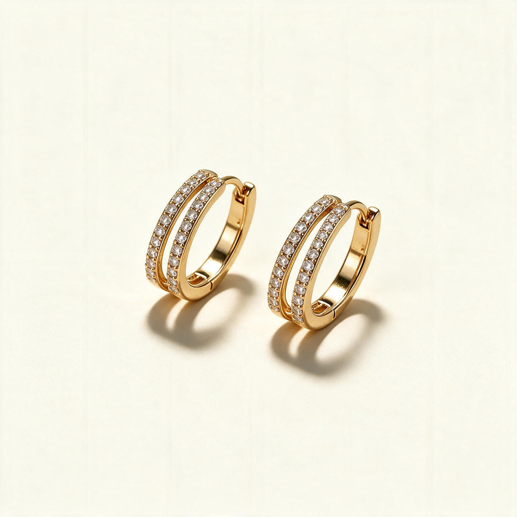 Gold-tone huggie hoop earrings with two rows of clear cubic zirconia pave on ivory background