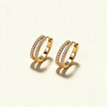 Gold-tone huggie hoop earrings with two rows of clear cubic zirconia pave on ivory background