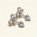 Silver-tone drop earrings with pave crystal bows and large heart-cut cubic zirconia drops