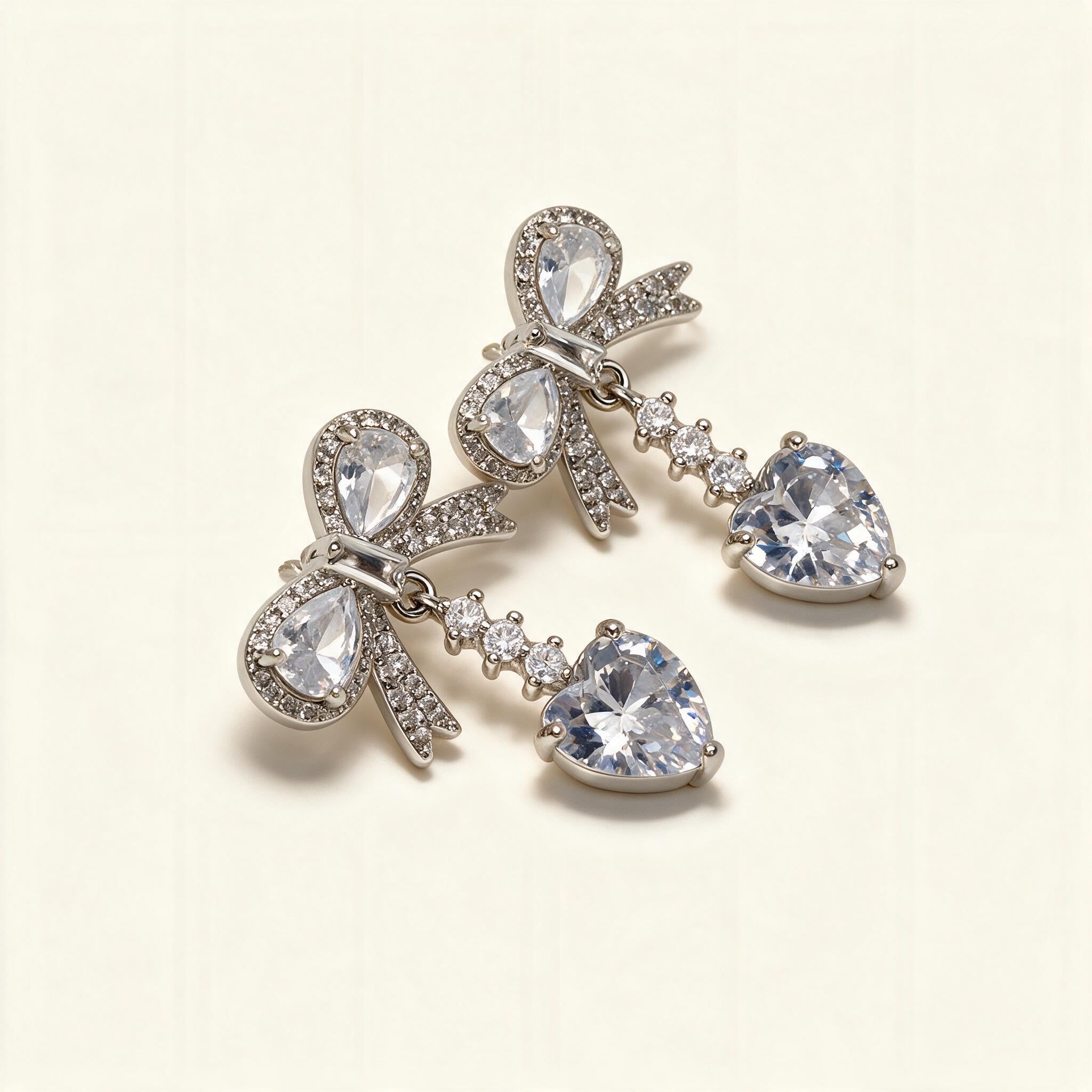 Silver-tone drop earrings with pave crystal bows and large heart-cut cubic zirconia drops
