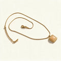 Gold-tone snake chain necklace with champagne square cabochon pendant