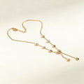 Gold-tone fine chain necklace with scattered crystal stations and slider drop