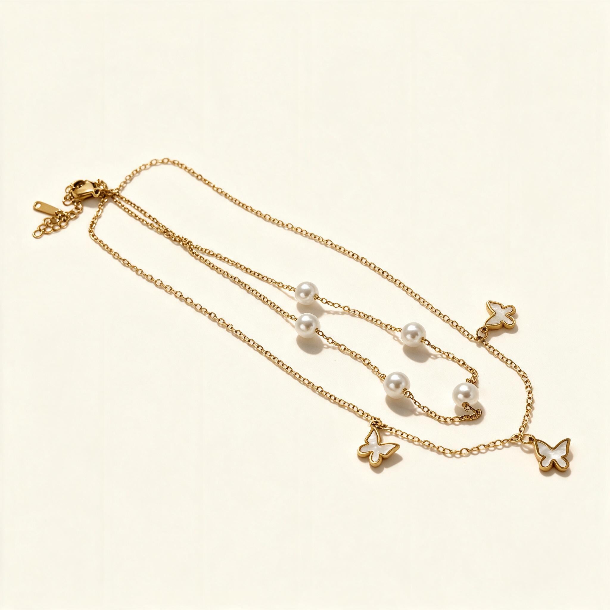 Gold-tone layered double chain necklace with pearls and butterfly charms