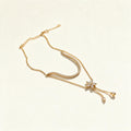 Gold-tone lariat necklace with pavé crystal arc, butterfly and hanging drops