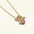 Gold-tone necklace with pink heart crystal pendant and pave triple-arc bail on a fine chain