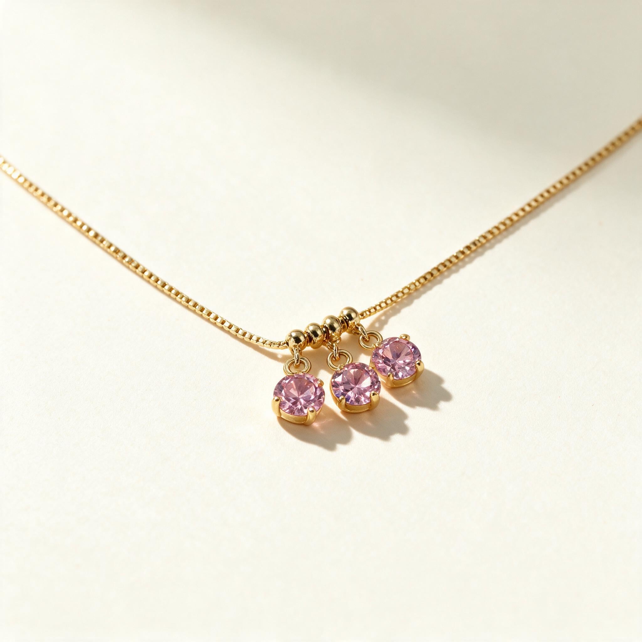 Gold-tone box chain necklace with three round pink cubic zirconia drop charms