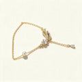Gold-tone fine chain necklace with a pave leaf and pear-cut crystal pendant, a shell pearl station and a crystal drop on the extender