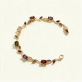 Gold-tone tennis bracelet with red, purple, olive and champagne oval stones