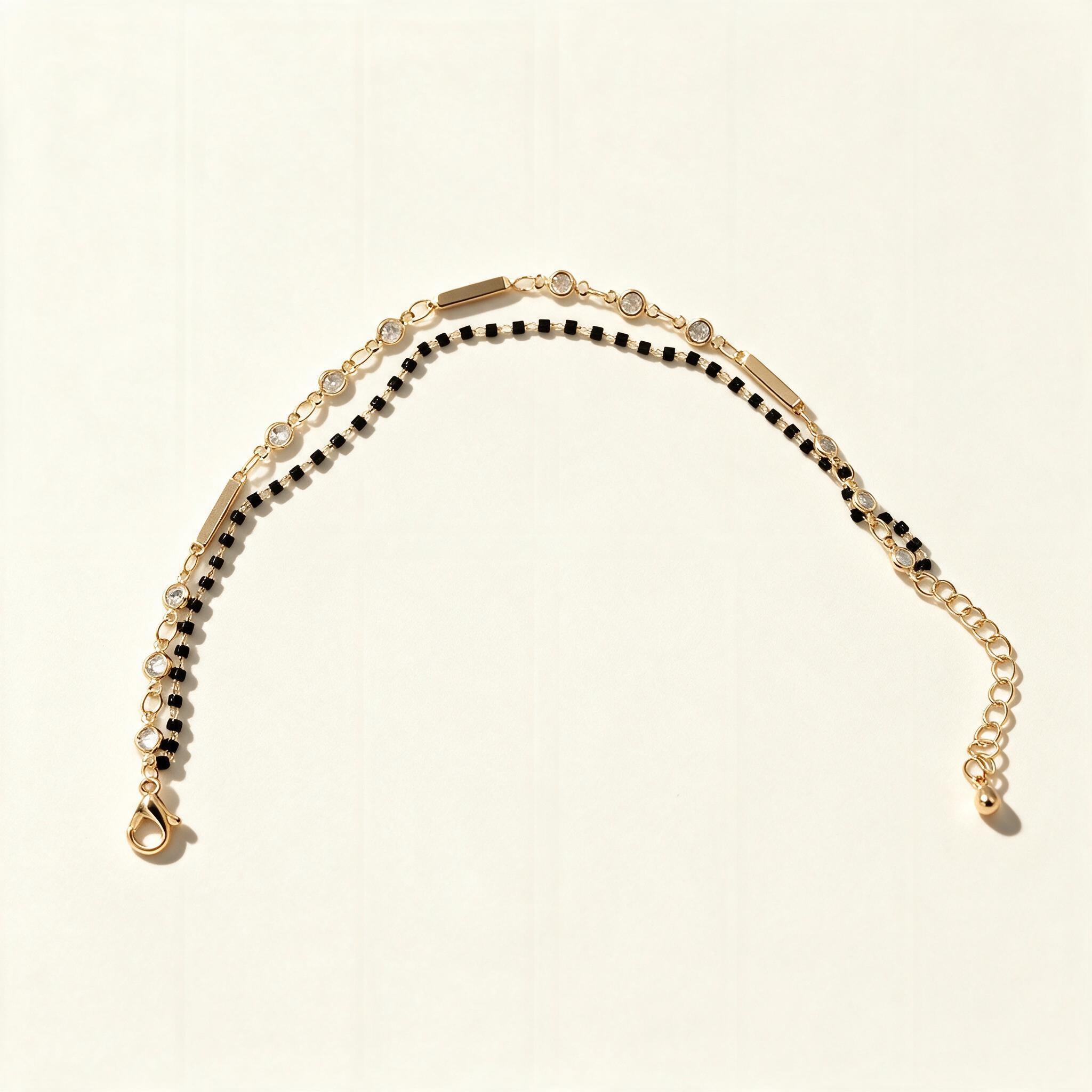 Gold-tone mangalsutra bracelet with black beads and clear cubic zirconia row
