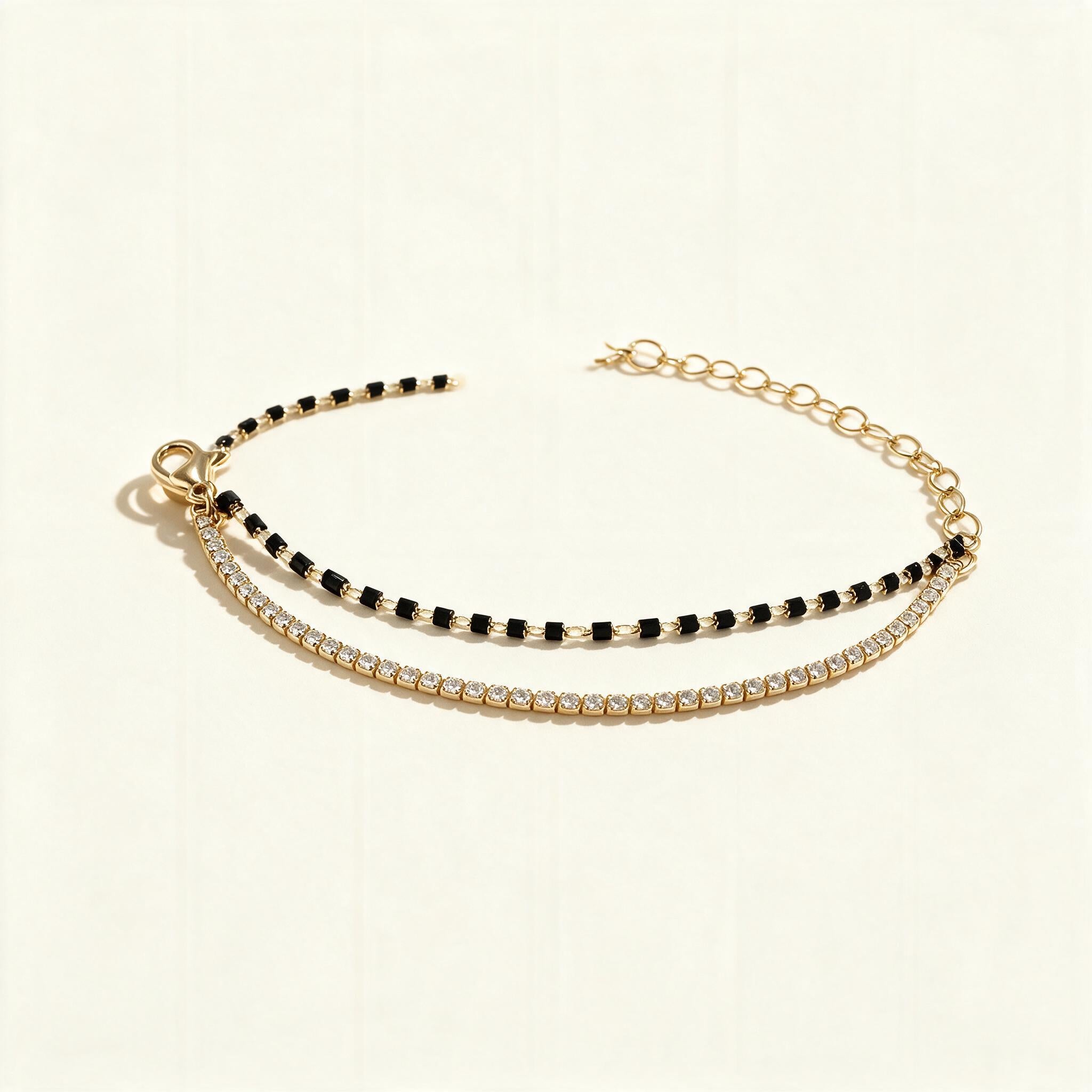 Gold-tone double row bracelet with black beads and clear cubic zirconia tennis line
