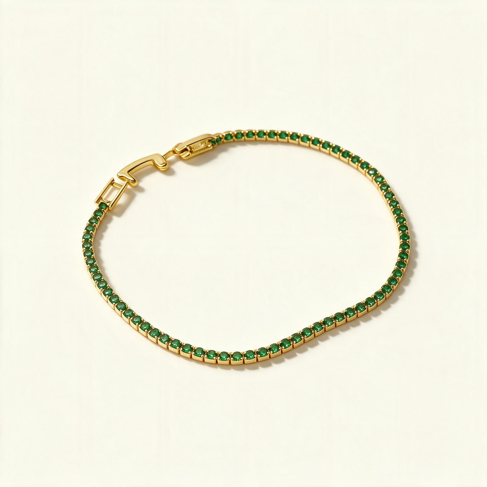 Gold-tone tennis bracelet set with a continuous row of emerald green stones