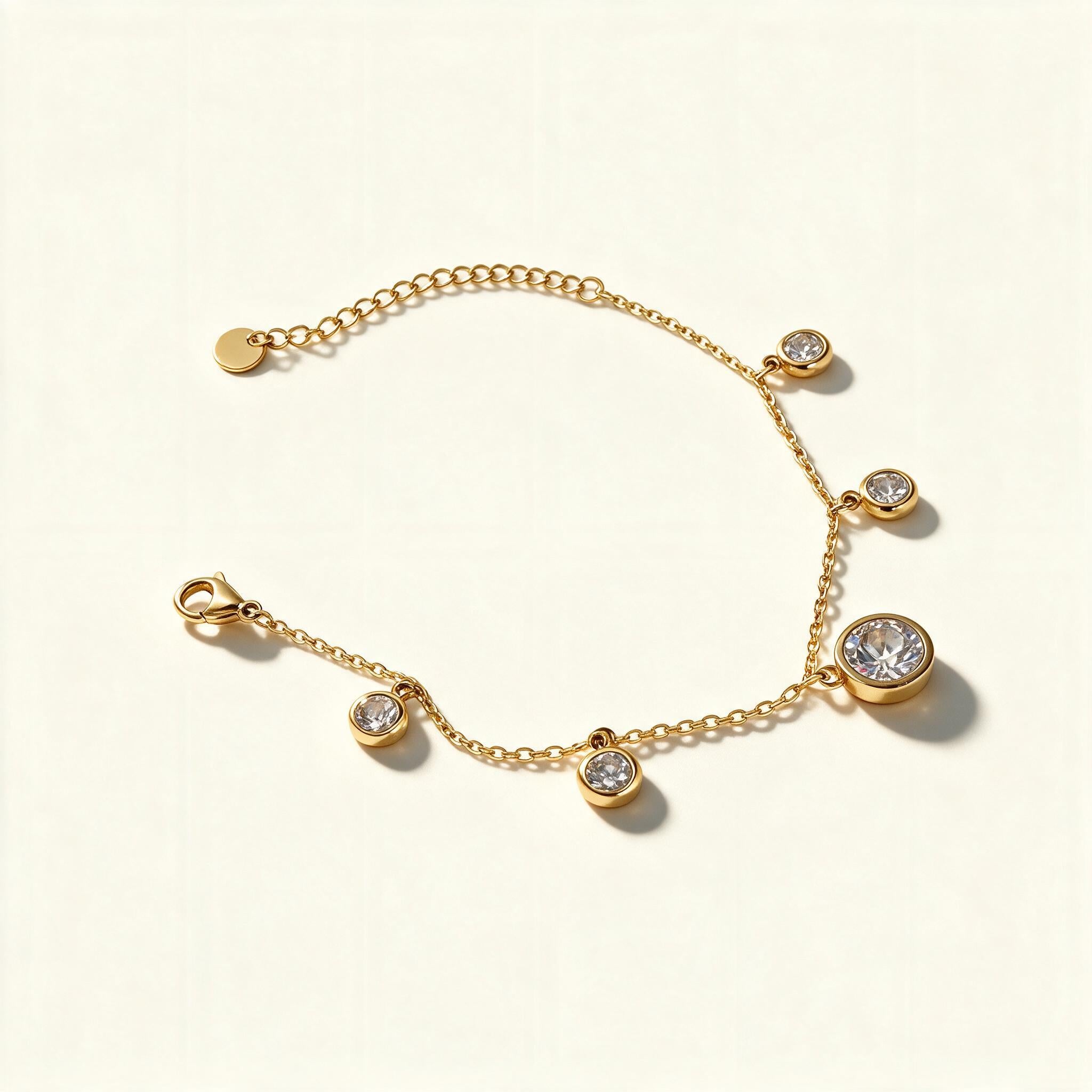 Gold-tone chain bracelet with graduated cubic zirconia bezel charms