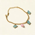 Gold-tone chain bracelet with turquoise enamel butterfly charms and pink flower bead