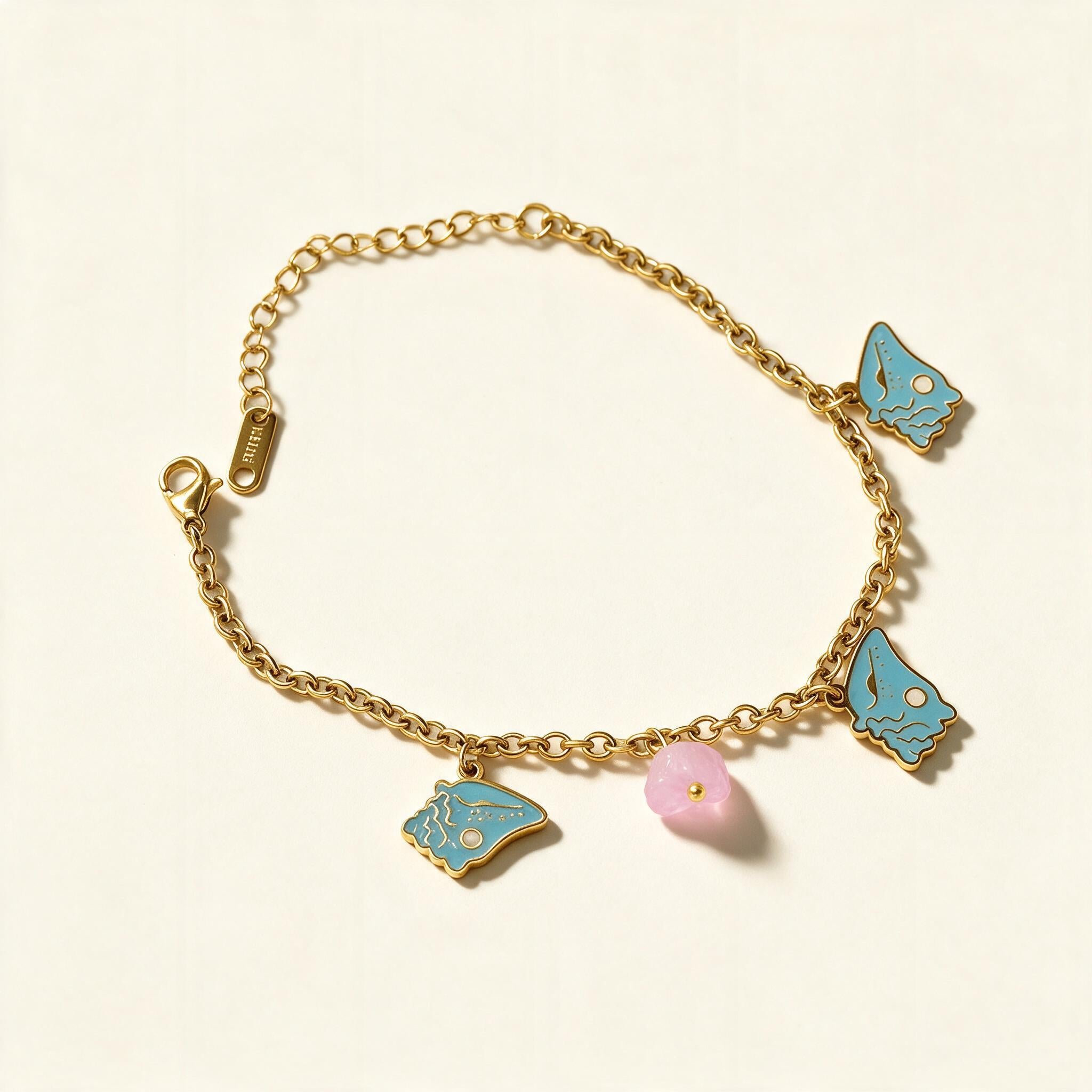 Gold-tone chain bracelet with turquoise enamel butterfly charms and pink flower bead