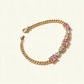 Gold-tone curb chain bracelet with emerald-cut pink stones and clear heart stones