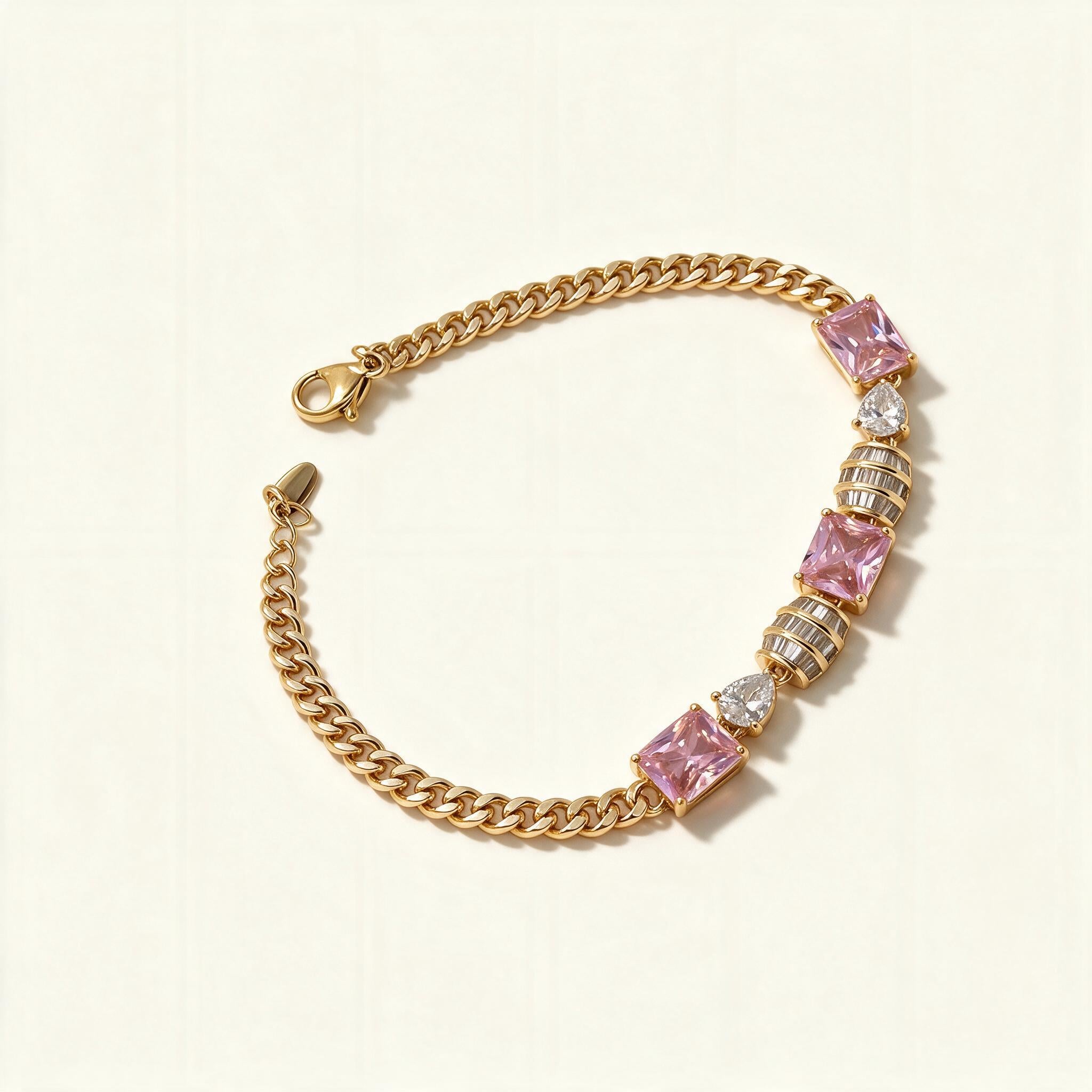 Gold-tone curb chain bracelet with emerald-cut pink stones and clear heart stones