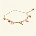 Gold-tone chain bracelet with red enamel cherry charms, daisy and pink beads
