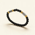 Black bead stretch bracelet with gold ball beads and faceted silver-tone barrel beads