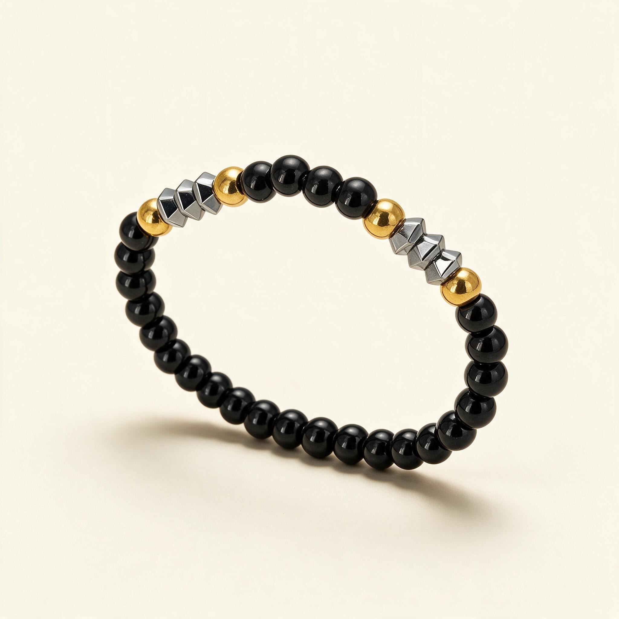 Black bead stretch bracelet with gold ball beads and faceted silver-tone barrel beads