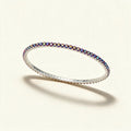 Silver-tone thin stretch tennis bracelet set with a row of iridescent pink and purple crystals