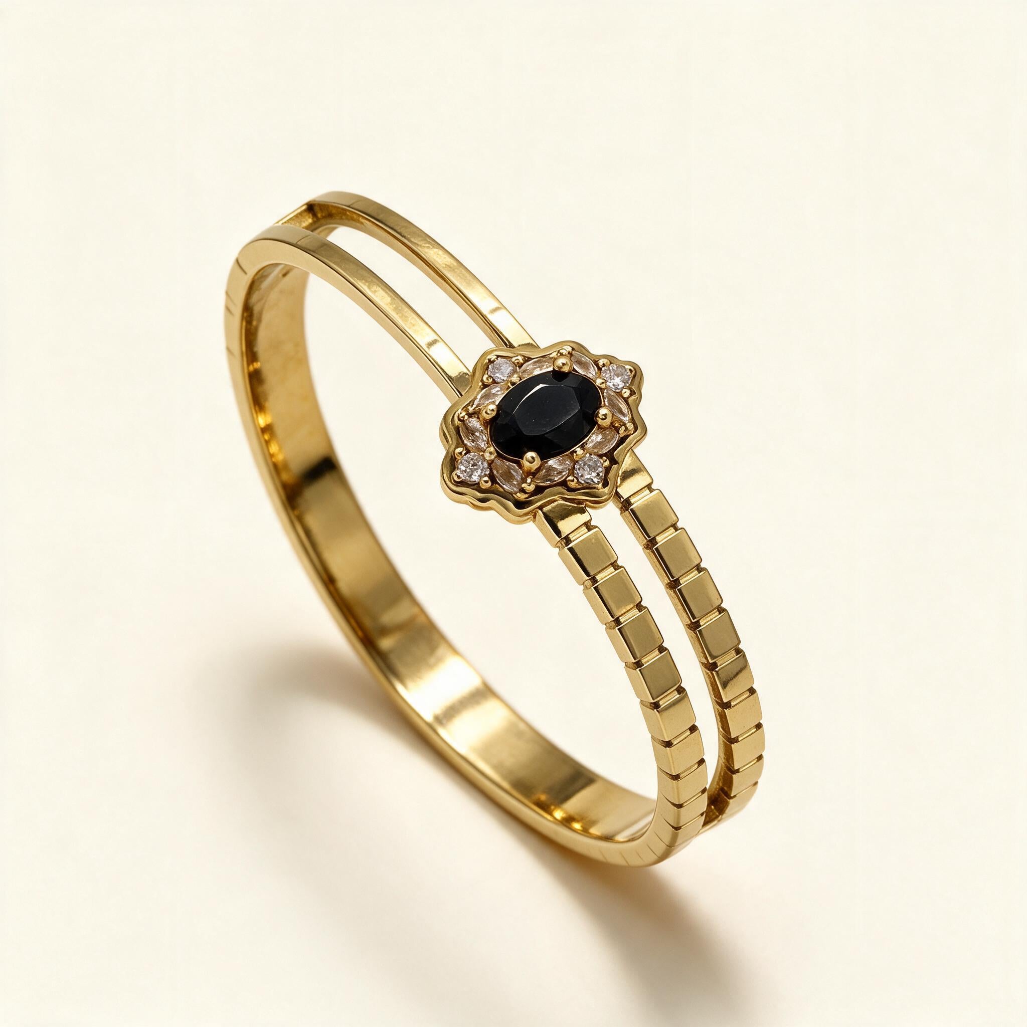 Gold-tone split band bangle with black oval stone in a crystal halo setting
