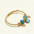 Gold-tone twisted cable bangle with turquoise beads and starfish, shell and coral charms