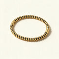 Gold-tone ribbed stretch bangle with rounded beads and dark spacer rings