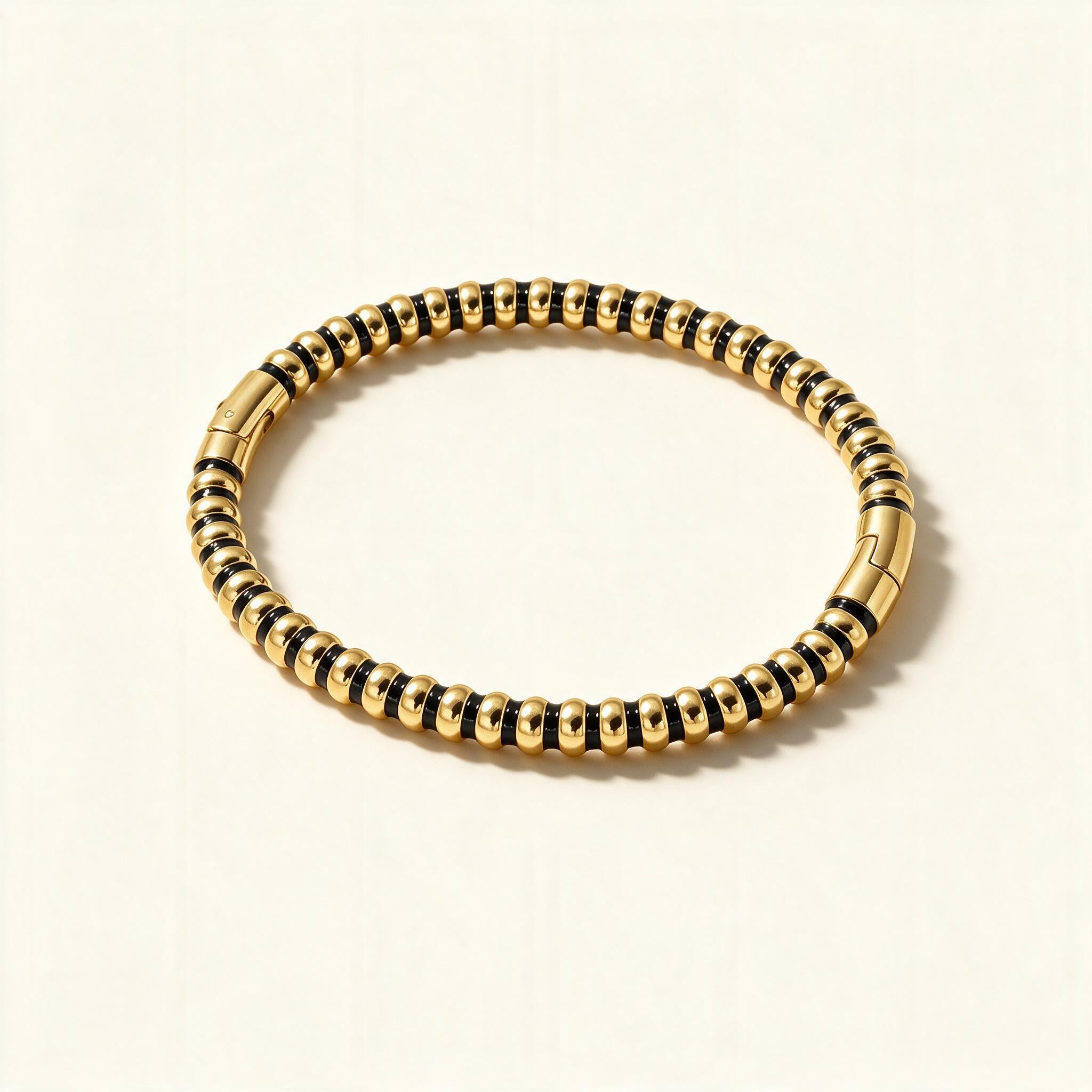 Gold-tone ribbed stretch bangle with rounded beads and dark spacer rings