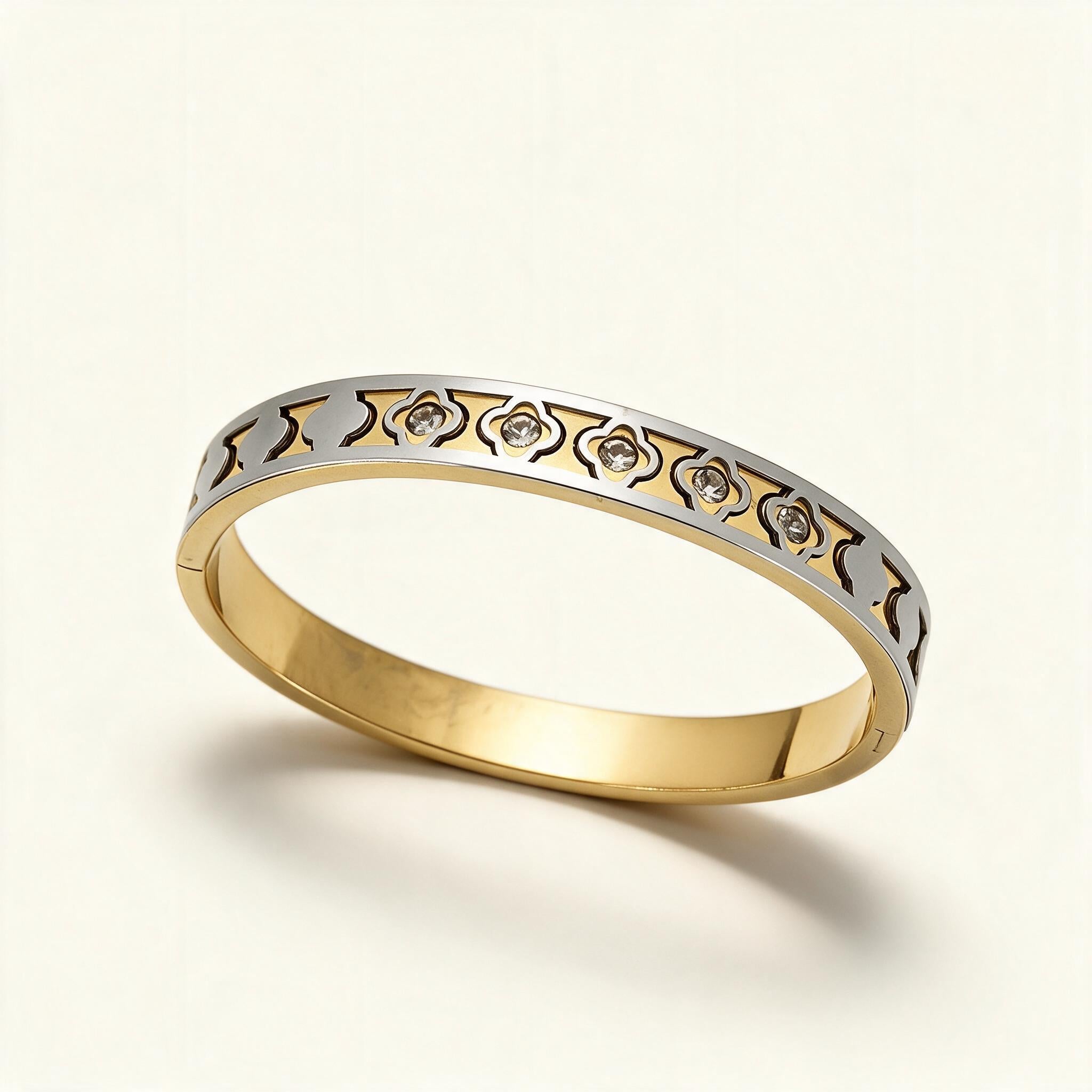Two-tone gold and silver bangle with cut-out clover lattice and clear cubic zirconia