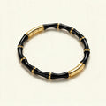 Slim gold-tone bangle made of glossy black enamel bamboo segments with gold rings