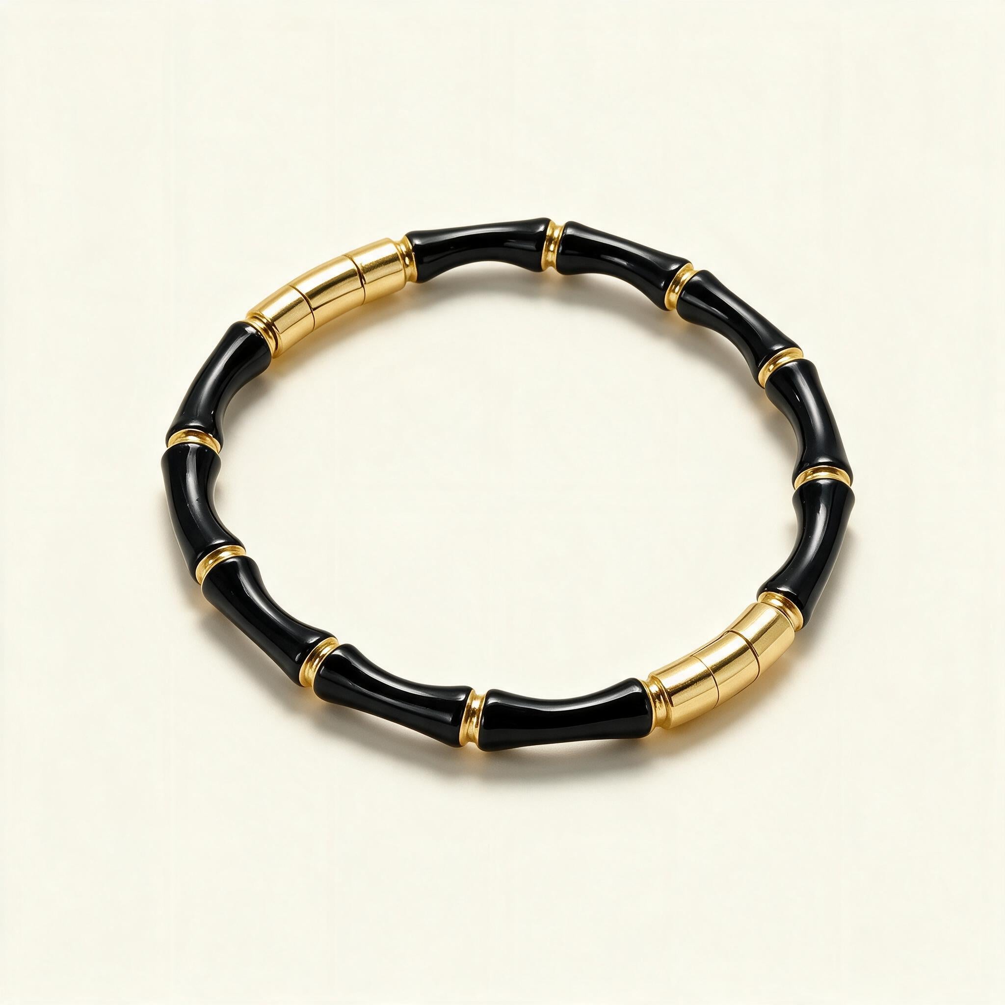 Slim gold-tone bangle made of glossy black enamel bamboo segments with gold rings