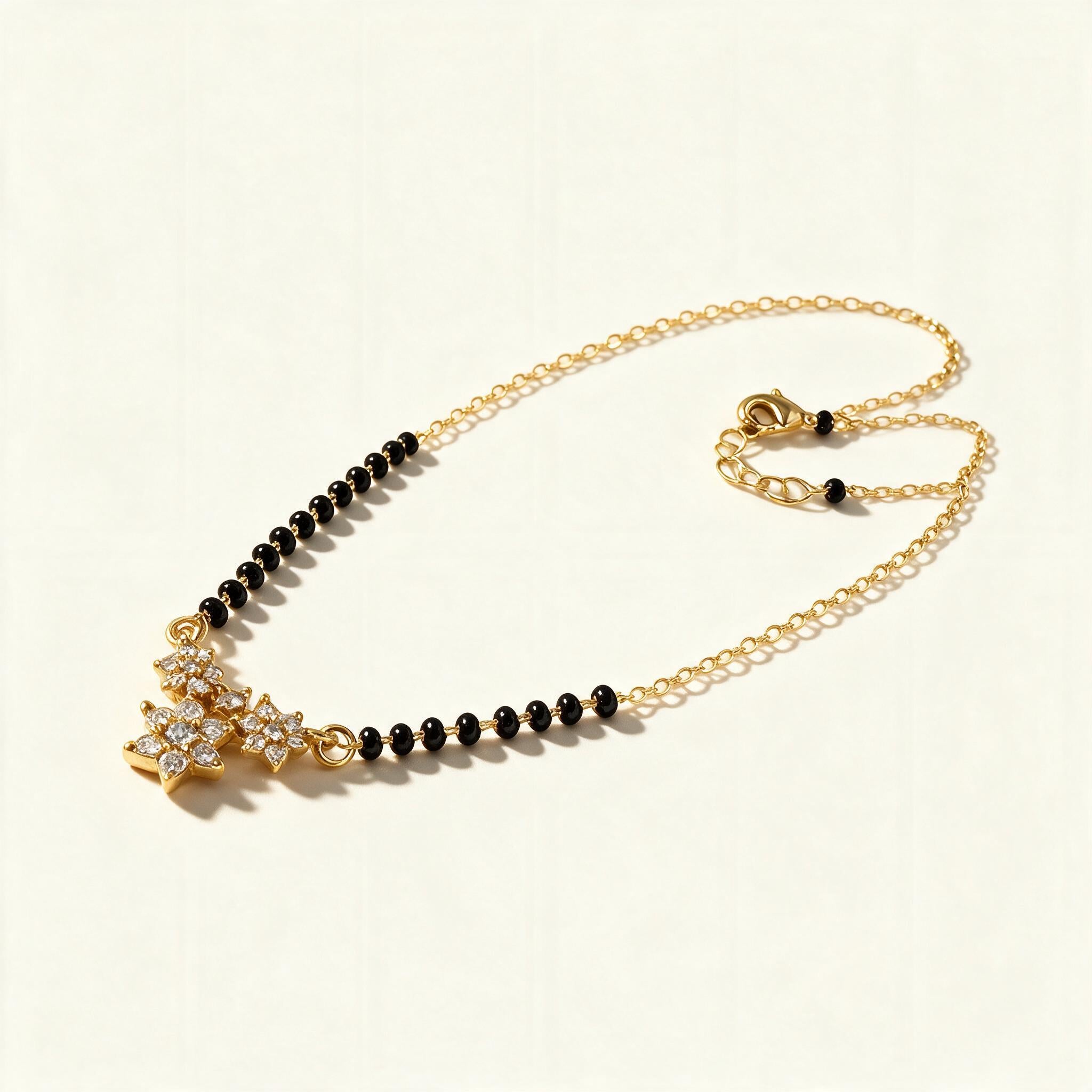 Gold-tone short mangalsutra with black beads and cubic zirconia star pendant