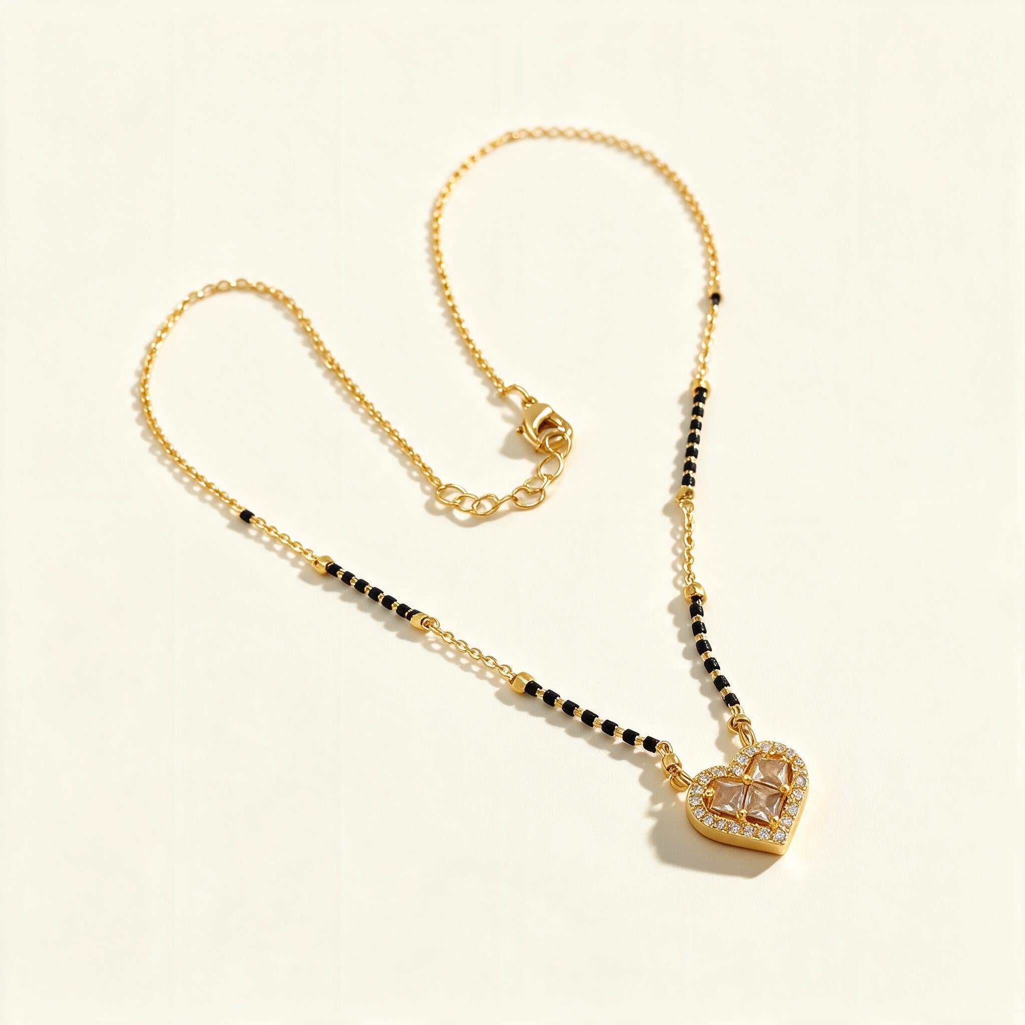 Gold-tone short mangalsutra with black beads and cubic zirconia heart pendant
