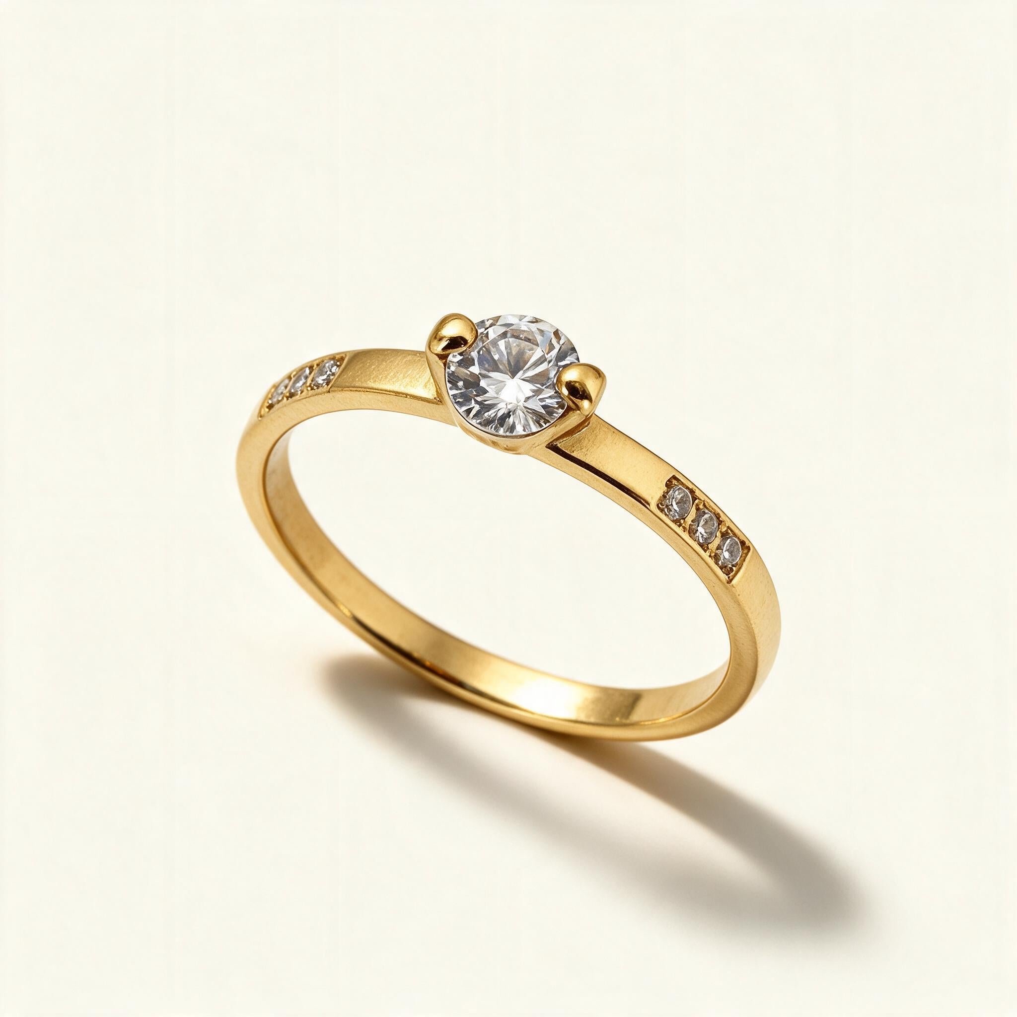 Gold-tone slim solitaire ring with a round cubic zirconia and pave-set stones on the shoulders