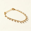 Gold-tone flat disc chain anklet with small hanging cubic zirconia drops on ivory background