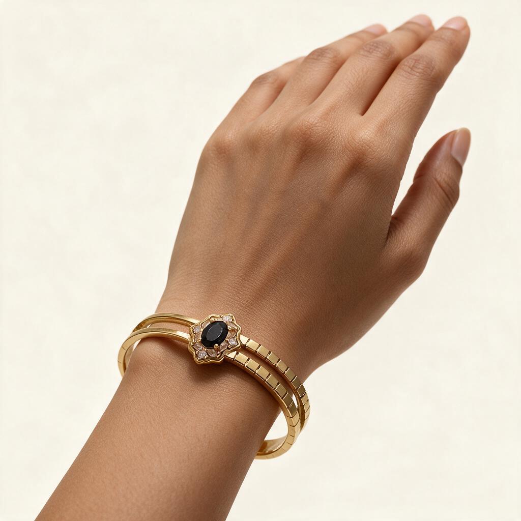 Woman wearing the Vesper gold tone black stone halo split band bangle on her wrist