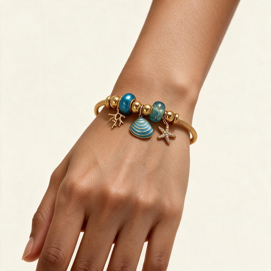 Woman wearing the Calypso gold tone turquoise ocean charm cable bangle on her wrist