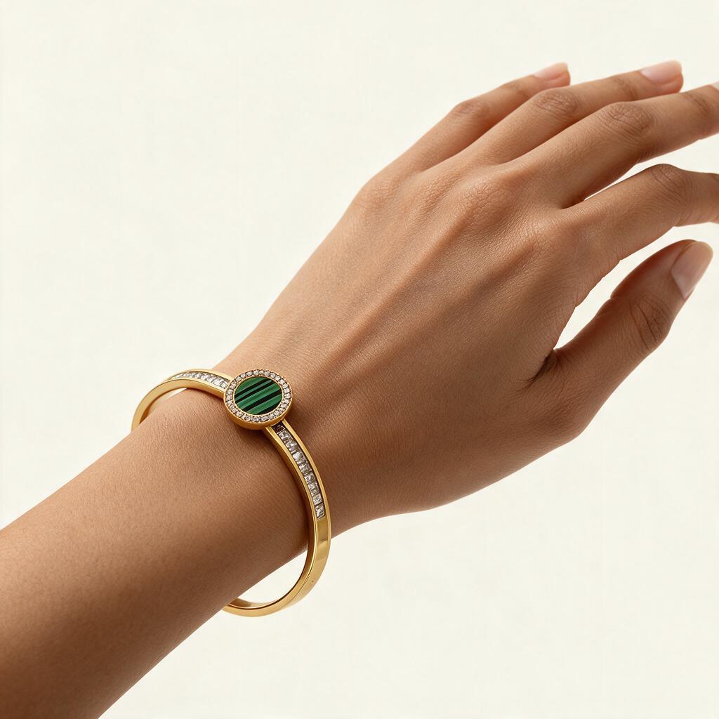 Woman wearing the Verdi gold tone malachite disc baguette bangle on her wrist