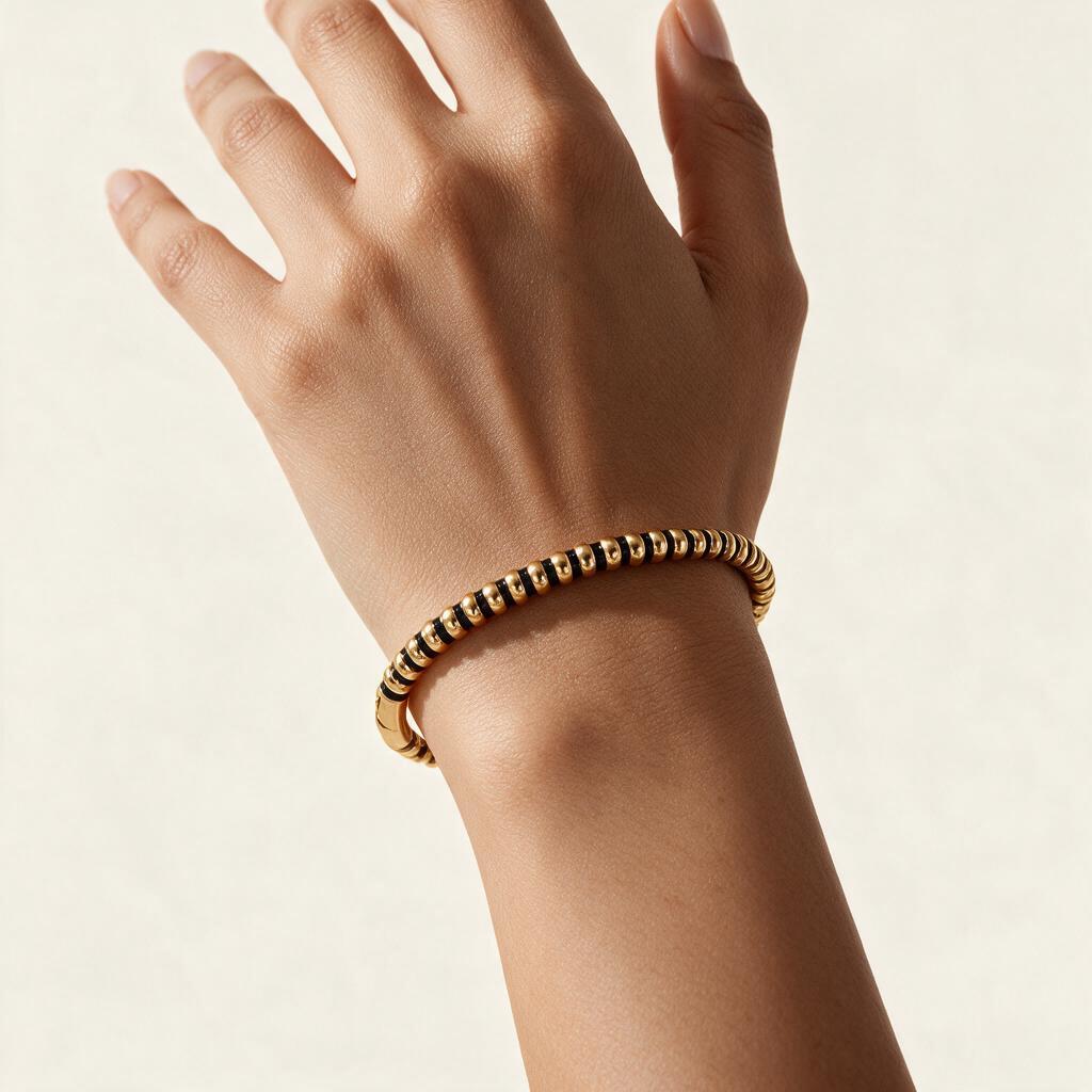 Woman wearing the Ravel gold tone ribbed bead stretch bangle on her wrist