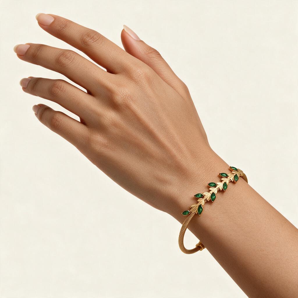 Woman wearing the Laurel gold tone green leaf cable bangle on her wrist