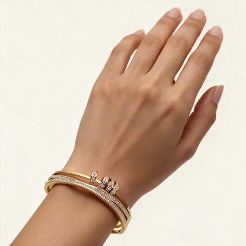 Woman wearing the Belmont gold tone pave double band wrap bangle on her wrist