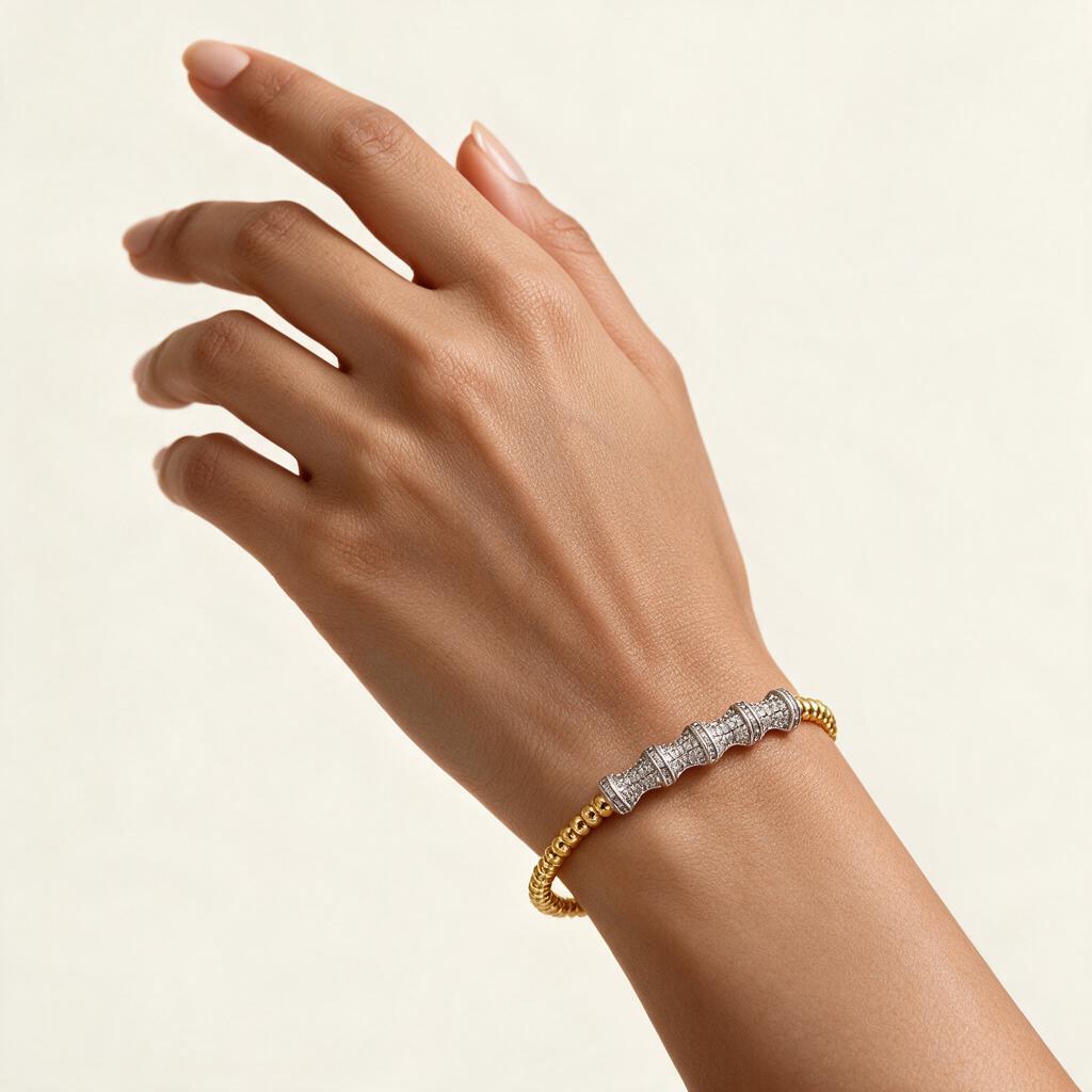 Woman wearing the Aurora two tone gold beaded flexible bangle on her wrist
