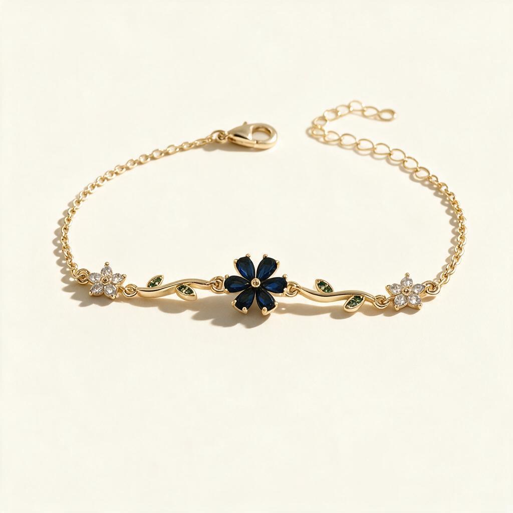 Gold-tone chain bracelet with navy blue flower, green leaf vines and clear crystal flowers on ivory background