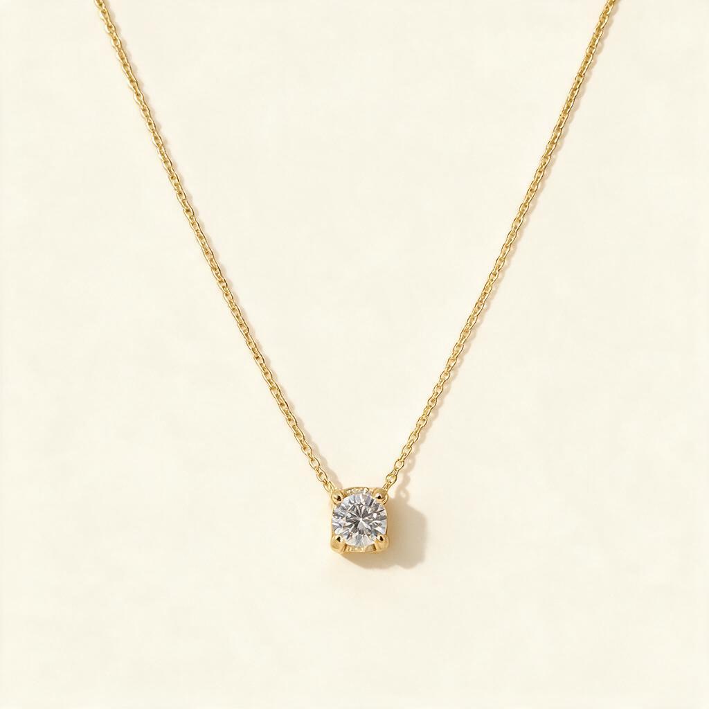 Gold-tone single fine chain necklace with a round cubic zirconia solitaire slider pendant on ivory background