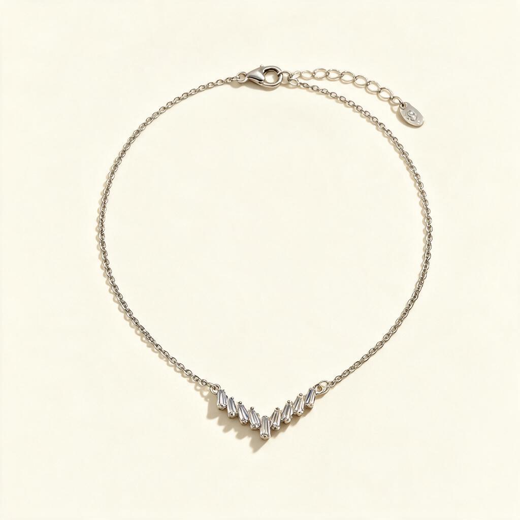 Silver-tone single chain necklace with a fan of baguette crystals on ivory background