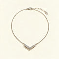 Silver-tone single chain necklace with a fan of baguette crystals on ivory background
