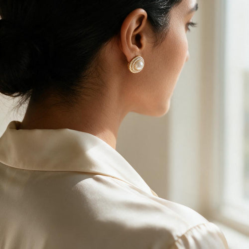 Woman in an ivory office shirt wearing the pearl halo stud earring